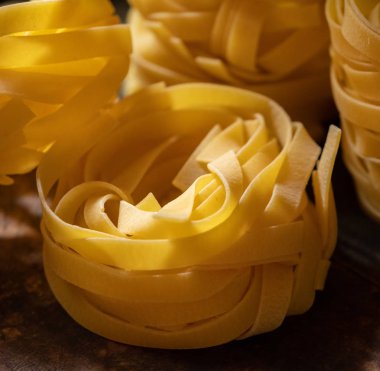 Ahşap tahta üzerinde kurutulmuş tagliatelle makarna