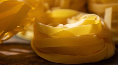 Ahşap tahta üzerinde kurutulmuş tagliatelle makarna