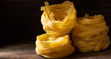 Ahşap tahta üzerinde kurutulmuş tagliatelle makarna