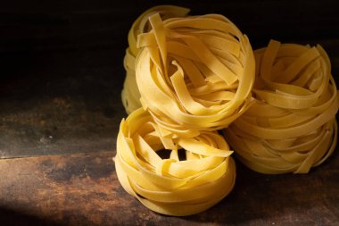 Ahşap tahta üzerinde kurutulmuş tagliatelle makarna