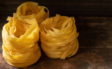 Ahşap tahta üzerinde kurutulmuş tagliatelle makarna