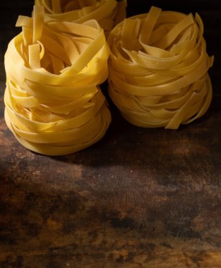 Ahşap tahta üzerinde kurutulmuş tagliatelle makarna