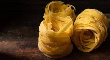 Ahşap tahta üzerinde kurutulmuş tagliatelle makarna