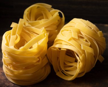 Ahşap tahta üzerinde kurutulmuş tagliatelle makarna