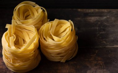 Ahşap tahta üzerinde kurutulmuş tagliatelle makarna