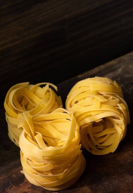 Ahşap tahta üzerinde kurutulmuş tagliatelle makarna