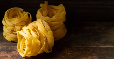 Ahşap tahta üzerinde kurutulmuş tagliatelle makarna