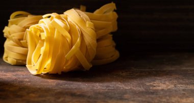 Ahşap tahta üzerinde kurutulmuş tagliatelle makarna