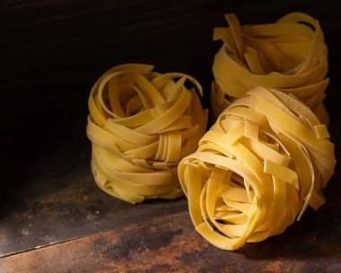 Ahşap tahta üzerinde kurutulmuş tagliatelle makarna