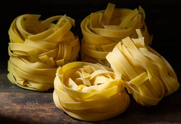 Ahşap tahta üzerinde kurutulmuş tagliatelle makarna