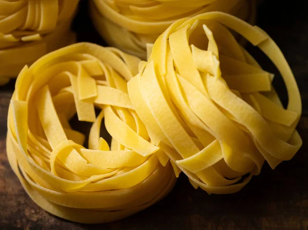 Ahşap tahta üzerinde kurutulmuş tagliatelle makarna