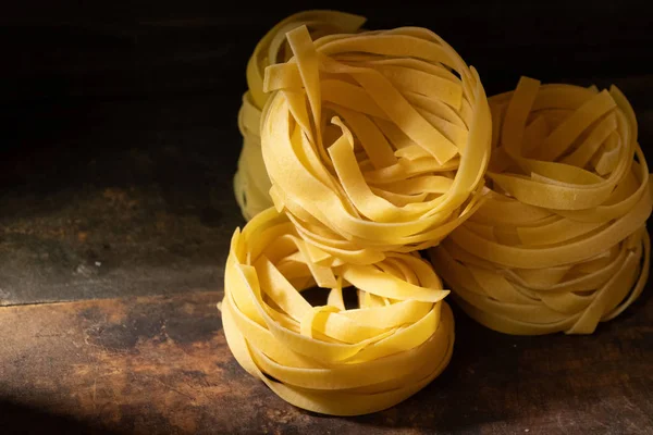 Ahşap tahta üzerinde kurutulmuş tagliatelle makarna