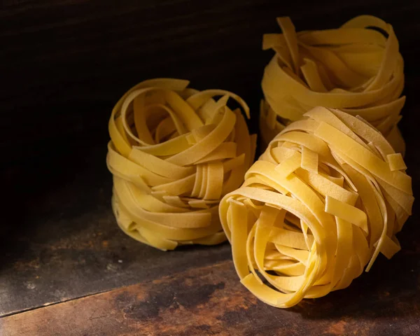 Ahşap tahta üzerinde kurutulmuş tagliatelle makarna