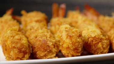 Ahşap arka plan üzerinde beyaz tabak içinde gevrek un kaplı derin kızarmış karides