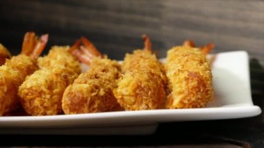 Ahşap arka plan üzerinde beyaz tabak içinde gevrek un kaplı derin kızarmış karides