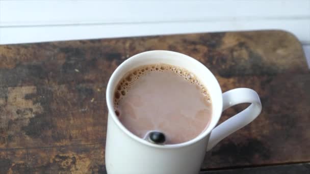 Ahşap Arka Plan Üzerinde Beyaz Bir Kupa Sıcak Çikolata — Stok video