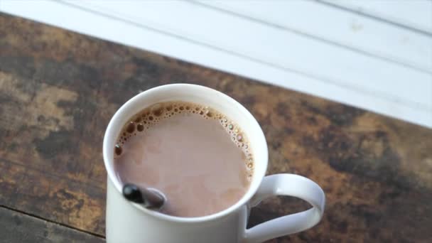 Chocolat chaud dans une tasse blanche sur fond en bois 