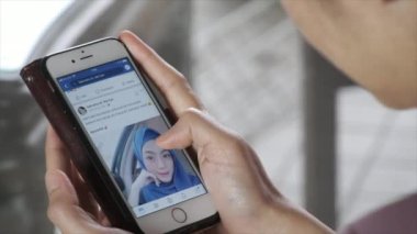 Kuala Lumpur, Malezya. Logged Facebook smartphone kullanan kadın. Mark Zuckerberg tarafından 2004 yılında kurulan, Facebook tüm dünyada 1.3 milyar etkin kullanıcı ile önde gelen sosyal ağ sitesi olan.