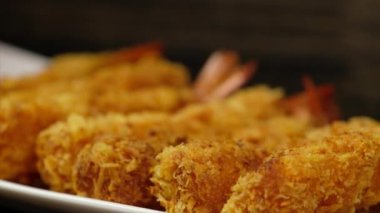 Ahşap arka plan üzerinde beyaz tabak içinde gevrek un kaplı derin kızarmış karides