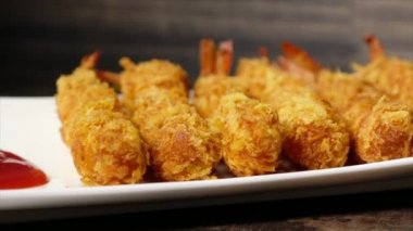 Ahşap arka plan üzerinde beyaz tabak içinde gevrek un kaplı derin kızarmış karides