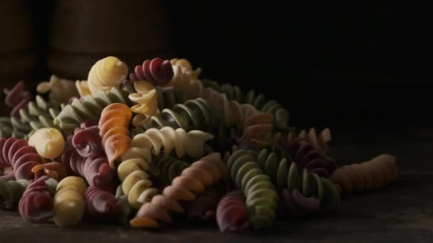 Getrocknete Farbige Fusilli Nudeln Auf Holzbrett — Stockvideo