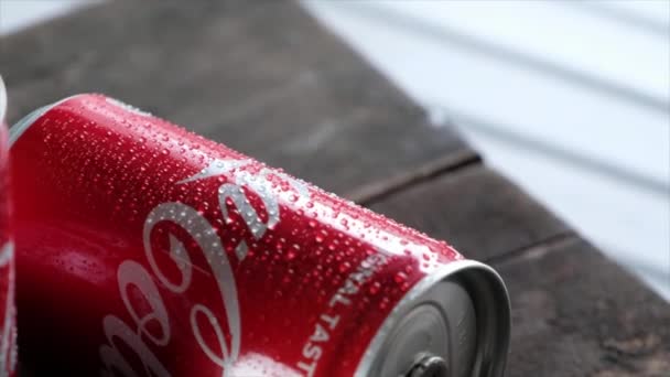 Coca cola může nápoje na dřevěné desce.