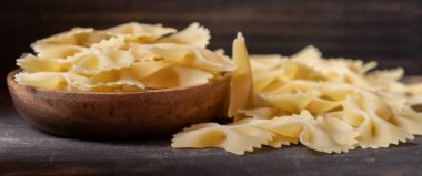 Ahşap arka plan üzerinde kurutulmuş farfalle makarna