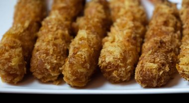 Ahşap arka plan üzerinde beyaz tabak içinde gevrek un kaplı derin kızarmış karides