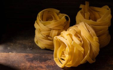 Ahşap tahta üzerinde kurutulmuş tagliatelle makarna