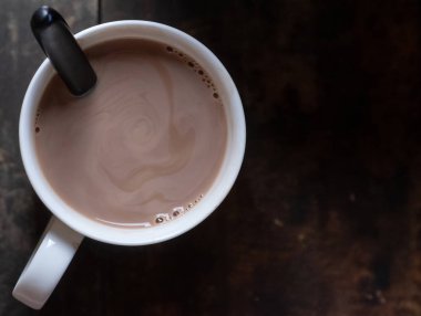 Ahşap arka plan üzerinde beyaz bir kupa sıcak çikolata