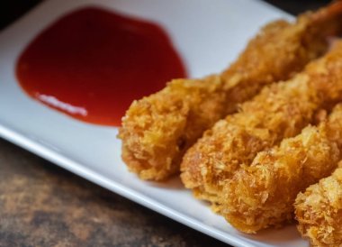 Ahşap arka plan üzerinde beyaz tabak içinde gevrek un kaplı derin kızarmış karides