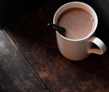 Ahşap arka plan üzerinde beyaz bir kupa sıcak çikolata