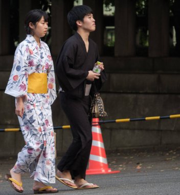Tokyo, Japonya - 14 Temmuz 2018. Yasukuni tapınak Mitama (veya ruh) sırasında Yaz Festivali smartphone ile geleneksel yukata elbiseli Japon çift.