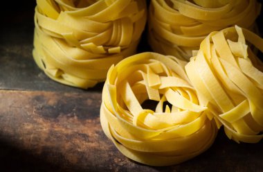 Ahşap tahta üzerinde kurutulmuş tagliatelle makarna