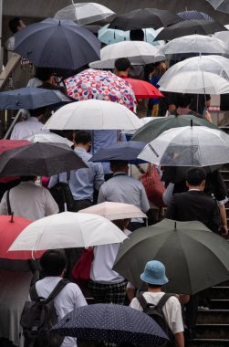 Tokyo, Japonya - 4 Temmuz 2018. Yayalar şemsiyelerle Shibuya içinde merdivenlerden yukarı yürümek.