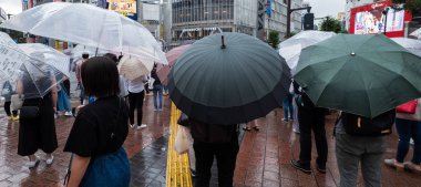 Tokyo, Japonya - 4 Temmuz 2018. Yağmurlu bir günde sırasında ünlü Shibuya kapış geçmeye bekleyen şemsiye ile yaya.