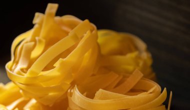 Ahşap tahta üzerinde kurutulmuş tagliatelle makarna