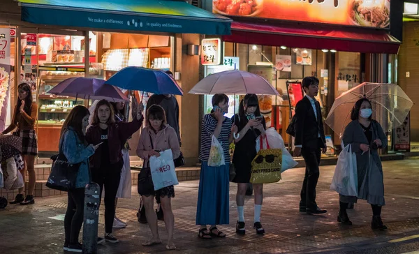 Menschen mit Regenschirm überqueren Fußgängerüberweg — Stockfoto