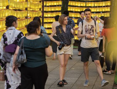 Tokyo, Japonya - 14 Temmuz 2018. Ziyaretçiler ve sarı kağıt fenerler Yasukuni tapınak Mitama (veya ruh) sırasında Yaz Festivali satırlar arasında yürüyen turist.