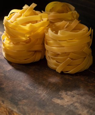 Ahşap tahta üzerinde kurutulmuş tagliatelle makarna