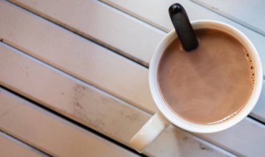 Ahşap arka plan üzerinde beyaz bir kupa sıcak çikolata