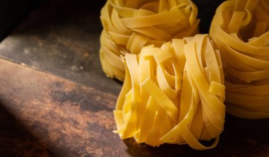 Ahşap tahta üzerinde kurutulmuş tagliatelle makarna