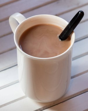 Ahşap arka plan üzerinde beyaz bir kupa sıcak çikolata