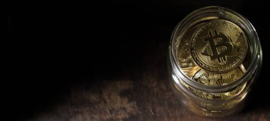 Bitcoins koyu ahşap arka plan üzerinde mason kavanoza