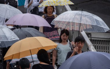 Tokyo, Japonya - 4 Temmuz 2018. Yayalar şemsiyelerle Shibuya sokakta yürüme.