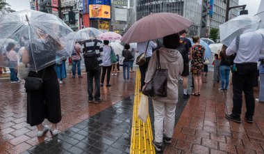 Tokyo, Japonya - 4 Temmuz 2018. Yağmurlu bir günde sırasında ünlü Shibuya kapış geçmeye bekleyen şemsiye ile yaya.
