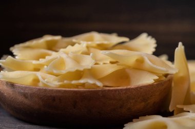 Ahşap arka plan üzerinde kurutulmuş farfalle makarna