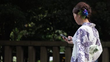 Tokyo, Japonya - 14 Temmuz 2018. Yasukuni tapınak Mitama (veya ruh) sırasında Yaz Festivali smartphone ile yukata elbiseli Japon kız.