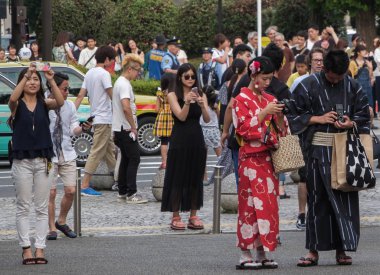 Tokyo, Japonya - 14 Temmuz 2018. Yasukuni tapınak Mitama (veya ruh) sırasında Yaz Festivali smartphone ile geleneksel yukata elbiseli Japon çift.