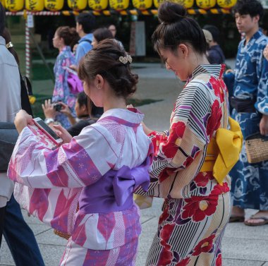 Tokyo, Japonya - 14 Temmuz 2018. Yasukuni tapınak Mitama (veya ruh) sırasında Yaz Festivali smartphone ile yukata elbiseli Japon kız.